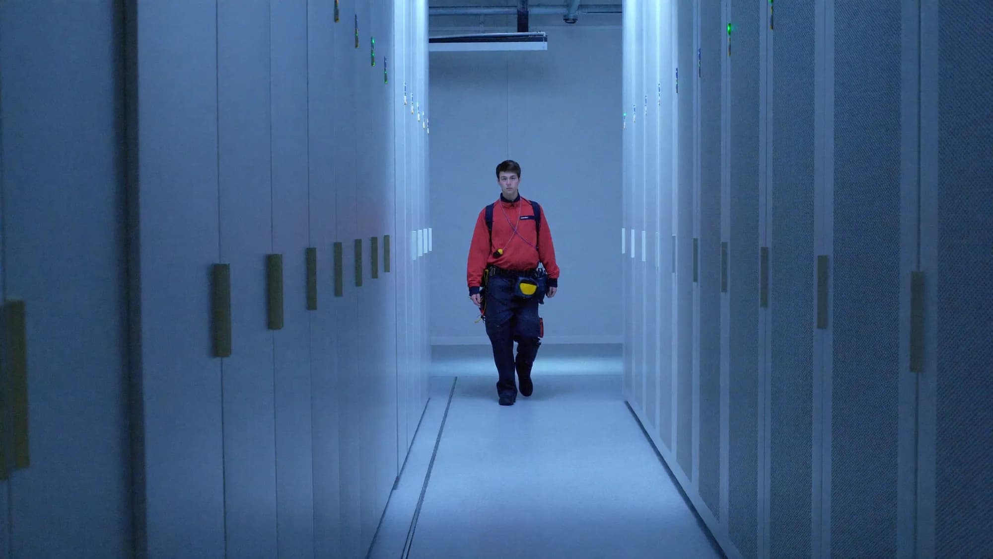 Technician walking a data center aisle between server racks, executing a cloud migration strategy