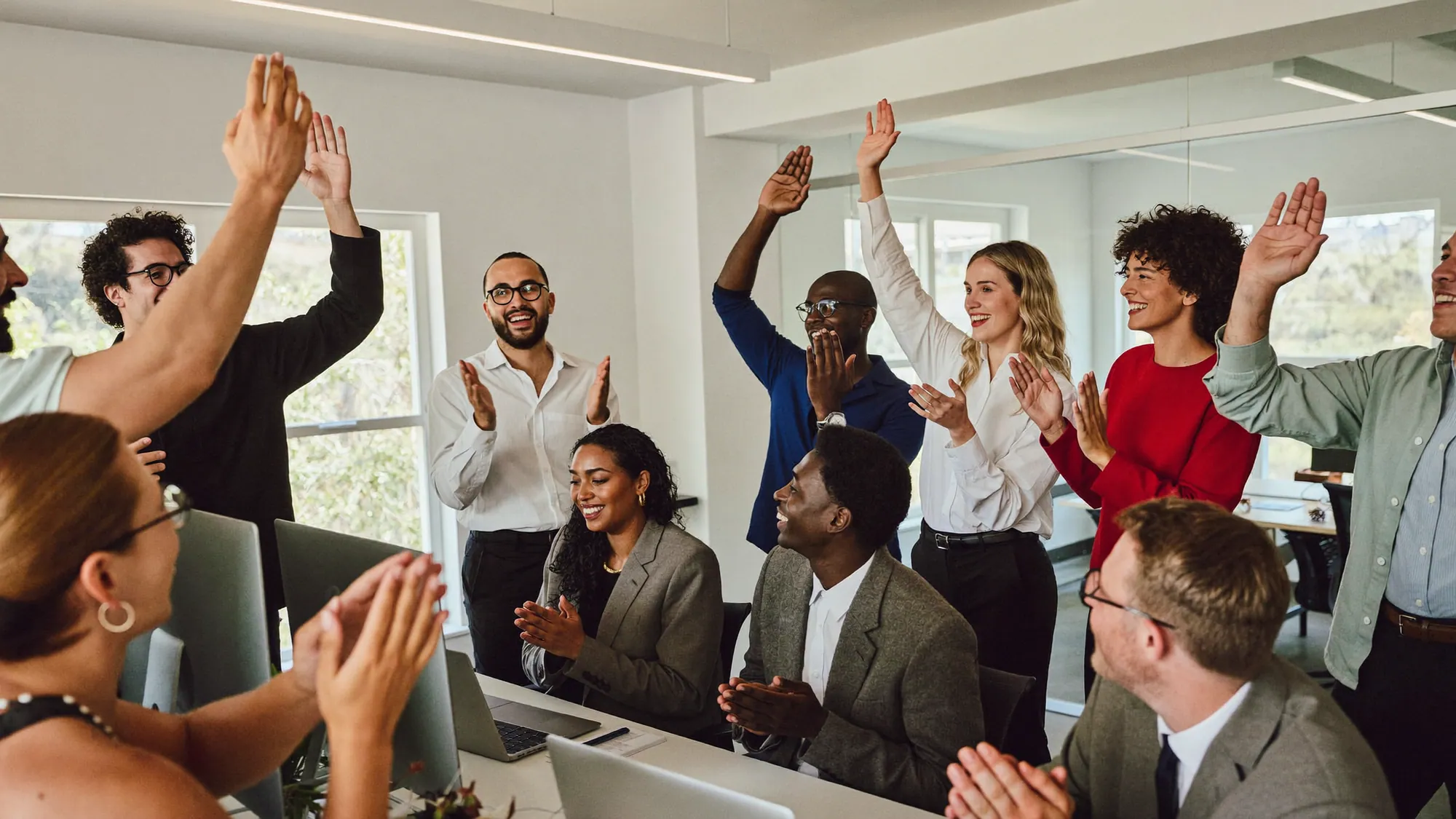Diverse sales team celebrating high CRM adoption, showing CRM implementation best practices