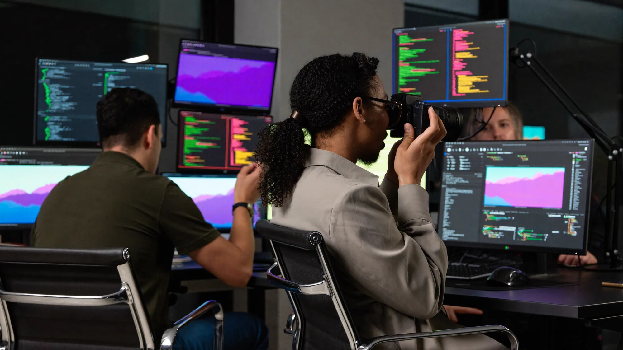 A data scientist at multiple monitors, comparing data analytics vs BI vs data science