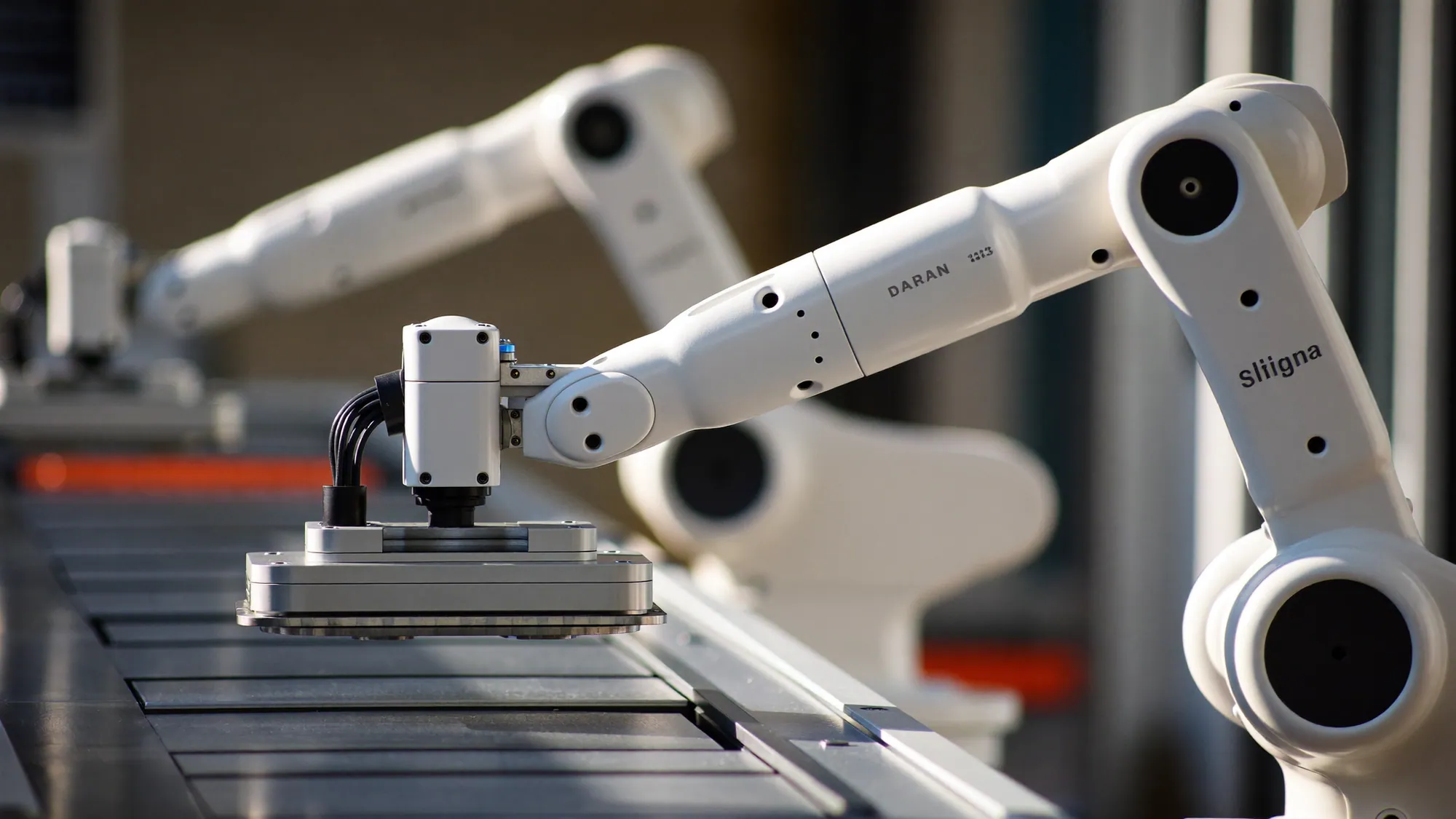 Industrial robotic arms on an automated assembly line, illustrating how to automate a business process