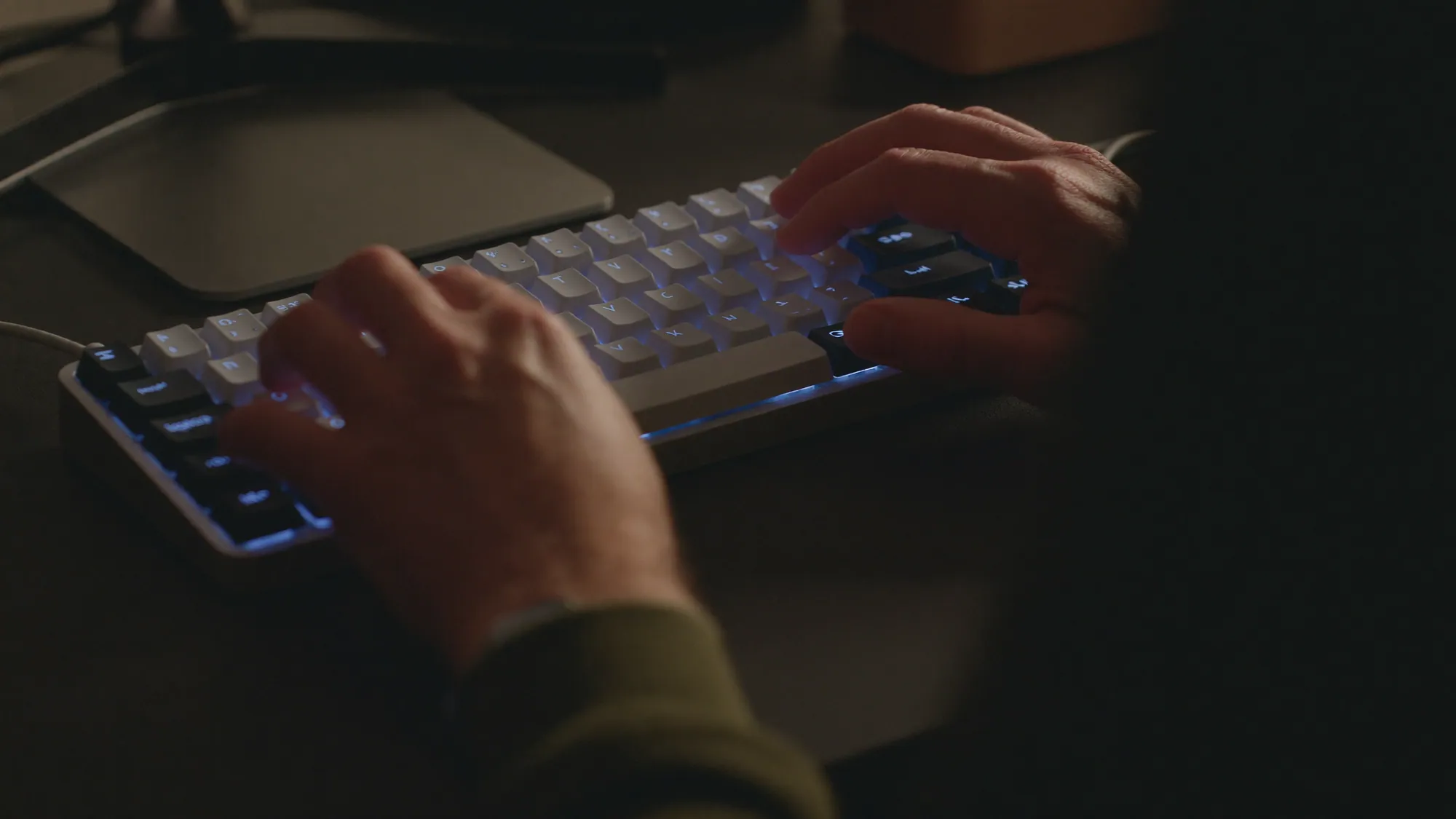 Developer's hands on a backlit mechanical keyboard, working through a technical SEO checklist