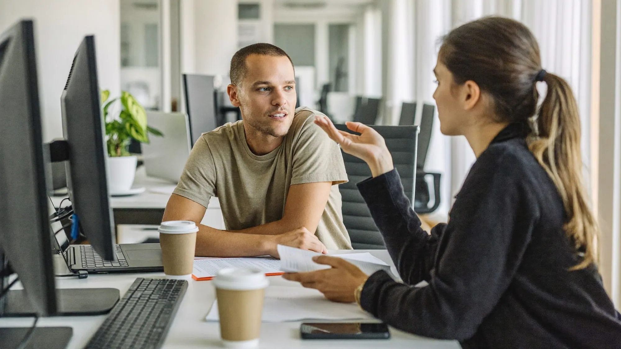 A marketing manager and a paid-media specialist reviewing a Google Ads campaign together before signing with a PPC agency