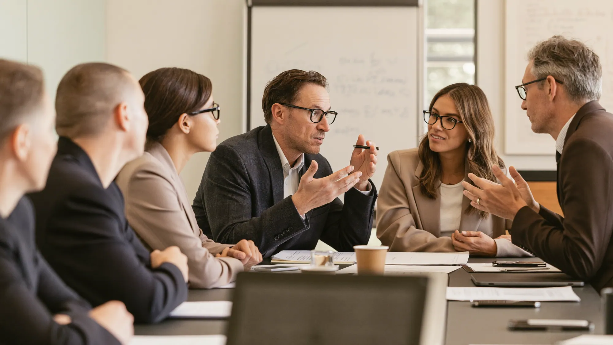Digital transformation consultants and a client team in an engaged discussion around a table evaluating a transformation roadmap